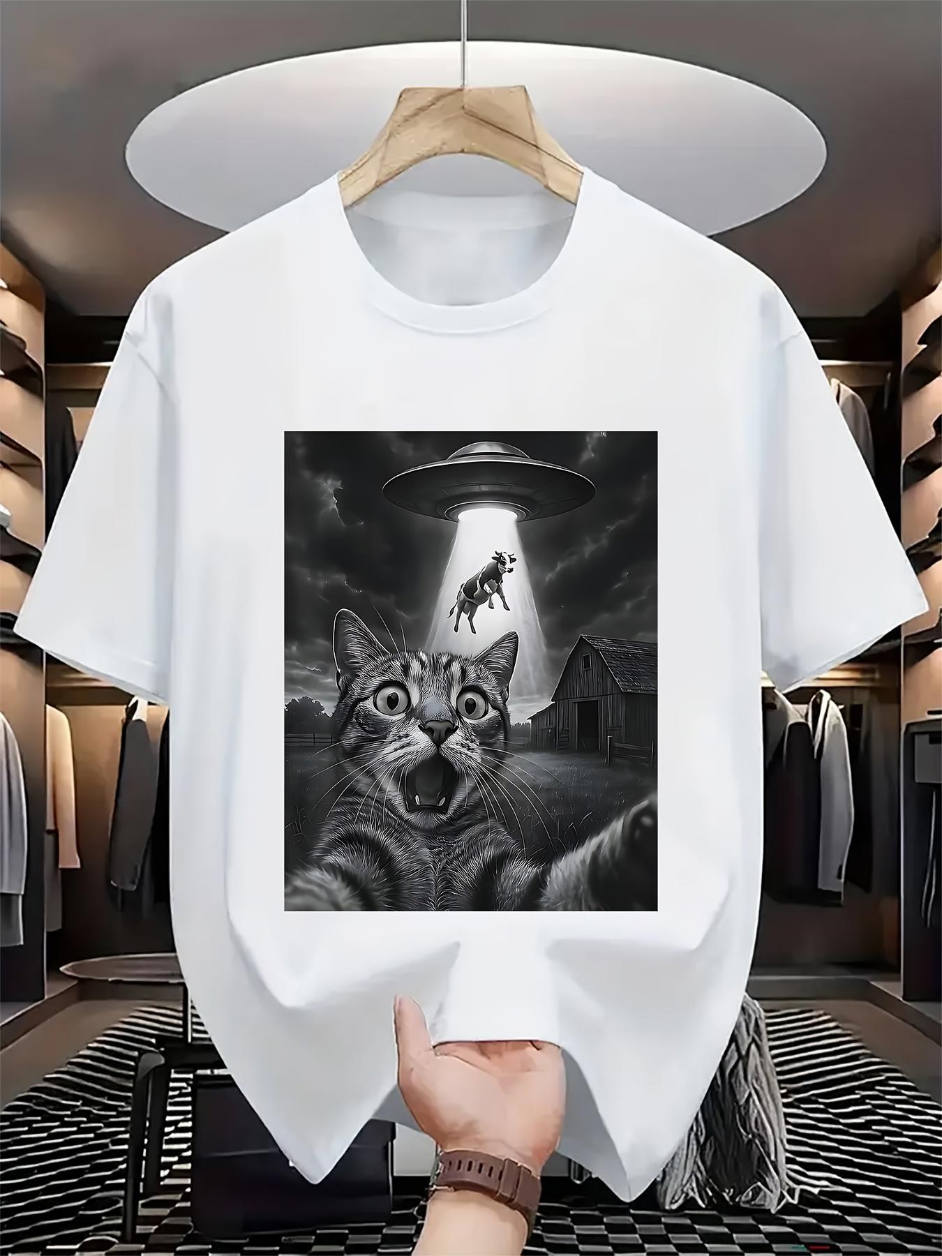Men's Graphic T-Shirt Dramatic Nighttime Scene With UFO Beaming Cows Above Surprised Cat
